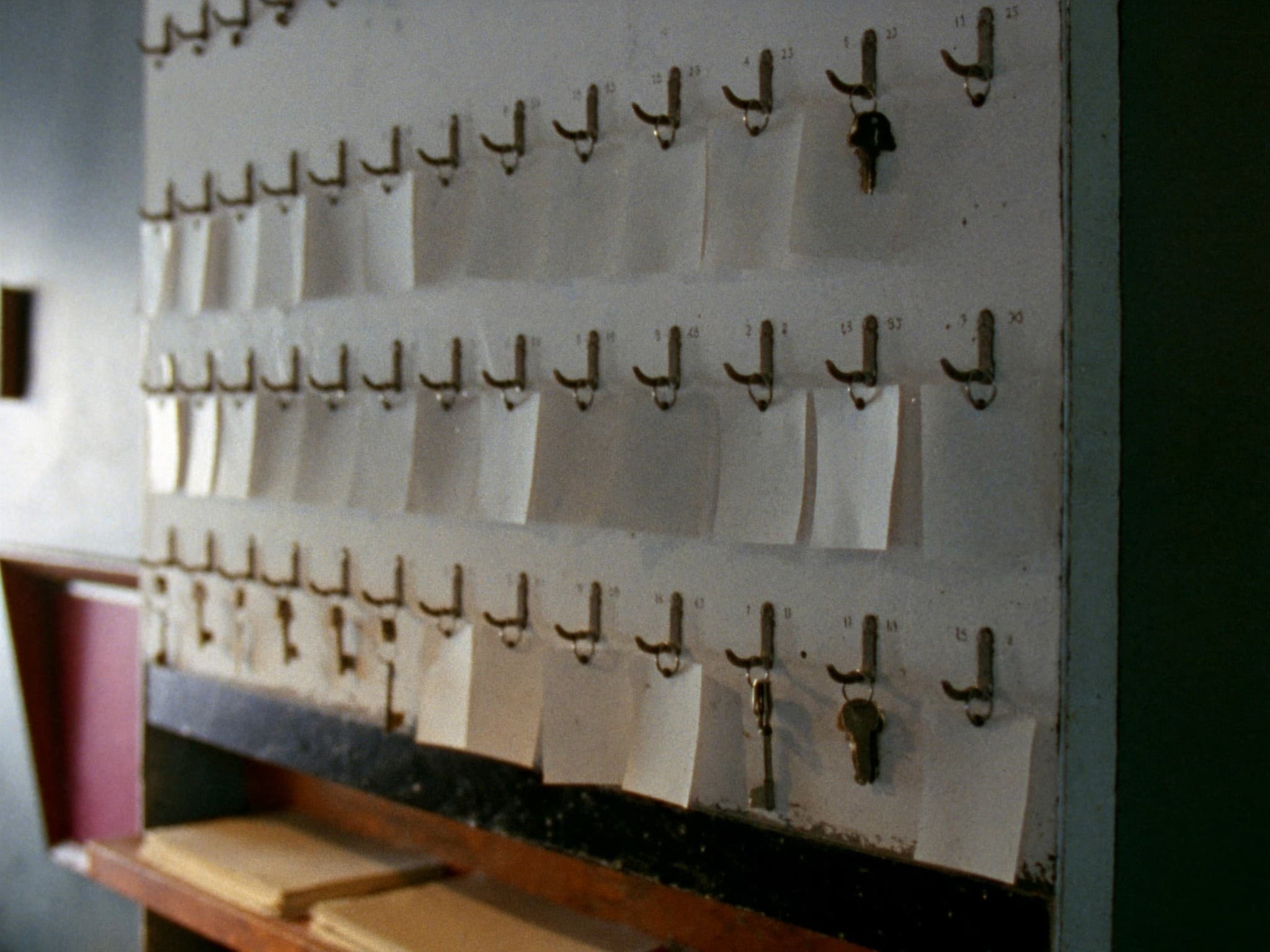 A key cabinet in an estate agency back office, sets of door keys hanging on numbered hooks