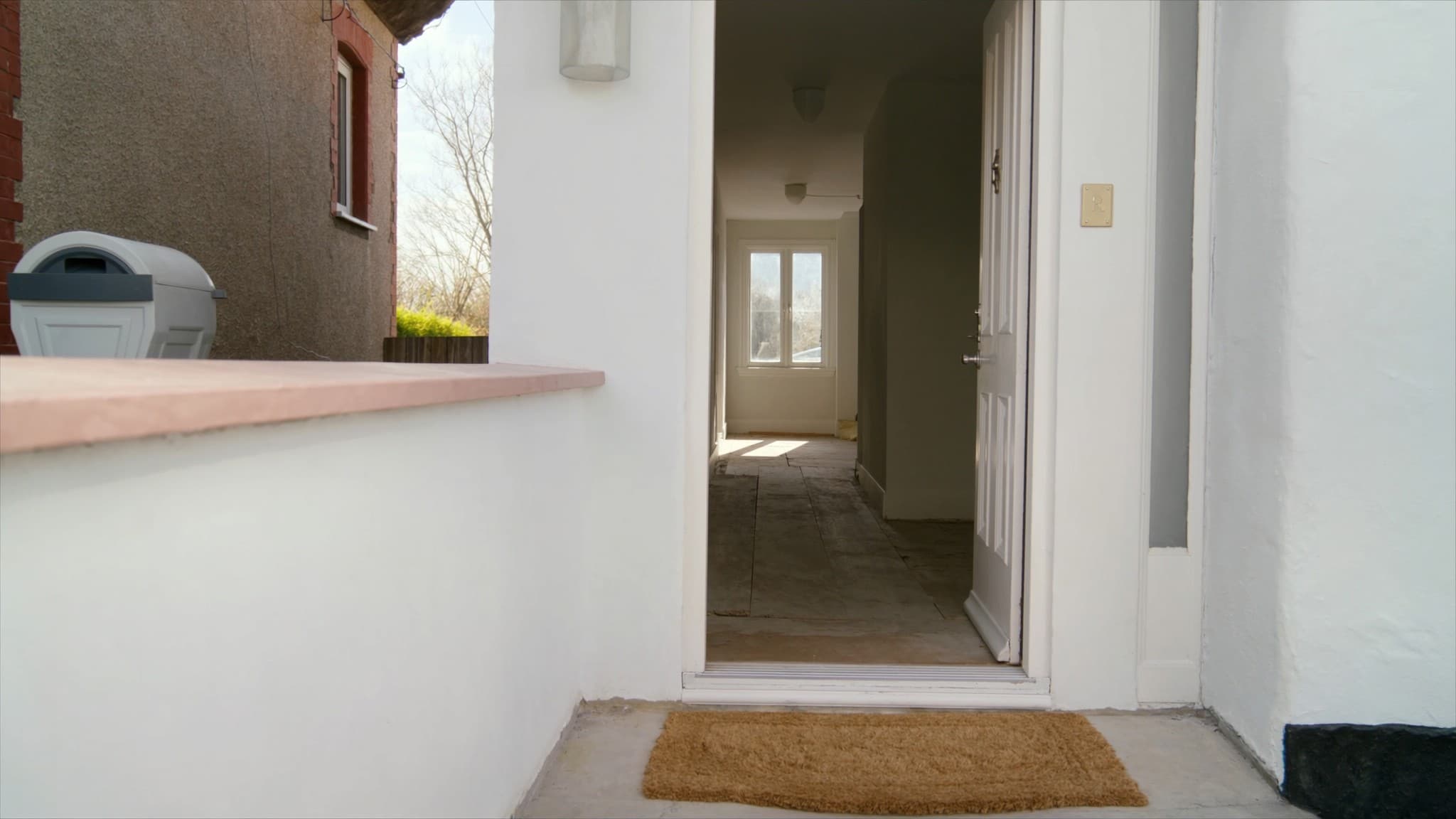 A British front door standing open onto an empty hallway on completion day