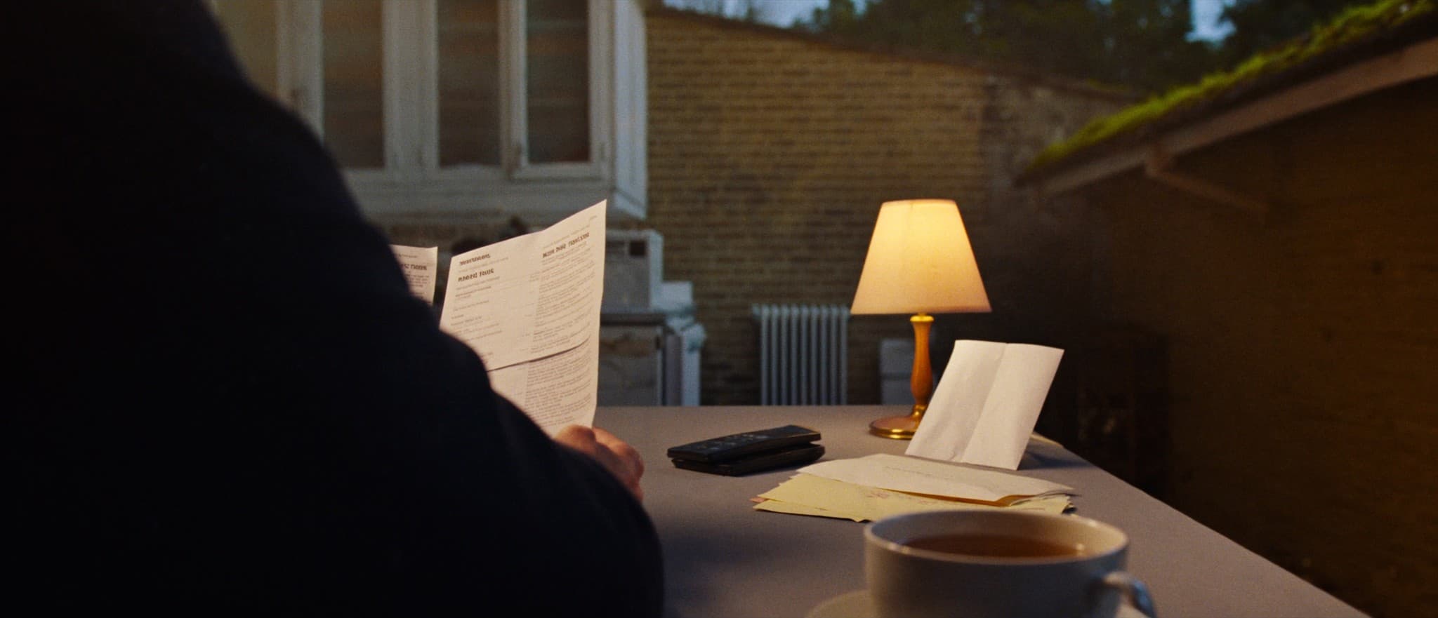 A homeowner at a kitchen table reviewing mortgage paperwork