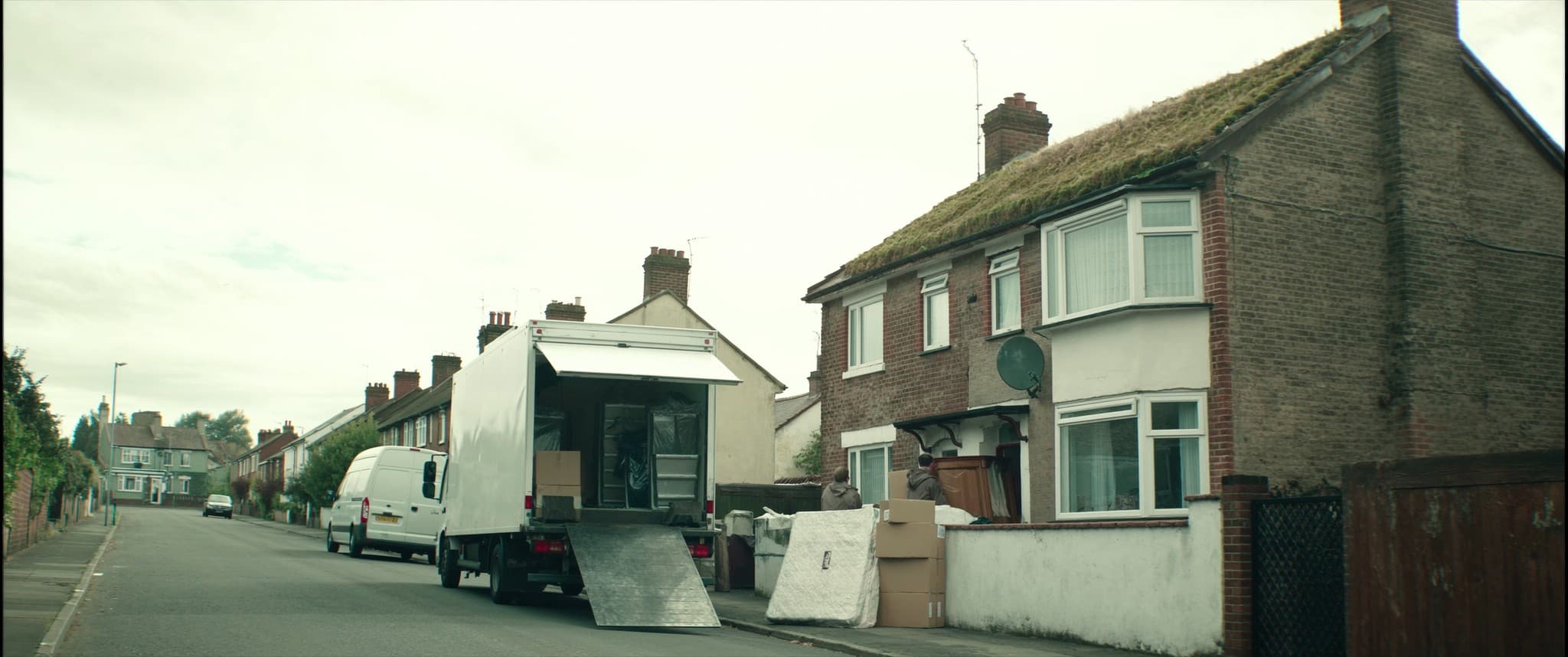Moving day on a residential street, a removals crew and a van outside a house