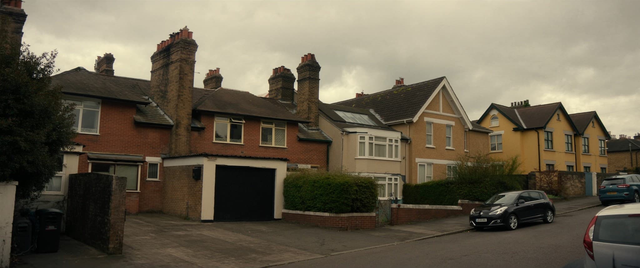 A UK residential street of mixed housing on a clear morning